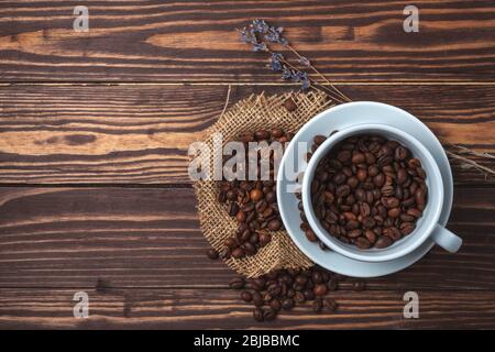 Tasse à café avec grains de café et branches de lavande sur un plan d'examen en bois. Vue de dessus Banque D'Images
