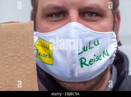 Schwerin, Allemagne. 29 avril 2020. Sven Gäde de l'agence de voyage Lulu Reisen est debout avec un garde-bouche devant la chancellerie d'État lors d'une manifestation. Compte tenu des faibles taux d'infection dans la région de Mecklembourg-Poméranie occidentale, les experts du voyage réclament une normalisation dans la crise de la couronne. Jusqu'à 50 représentants des voyagistes utilisent l'action pour attirer l'attention sur leur situation économique difficile. D'autres participants ne sont pas autorisés en raison des règles de distance Corona actuelles. Crédit: Jens Büttner/dpa-Zentralbild/dpa/Alay Live News Banque D'Images