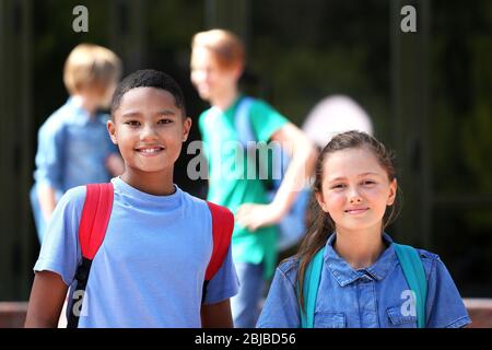 Mignons enfants debout près de l'école Banque D'Images