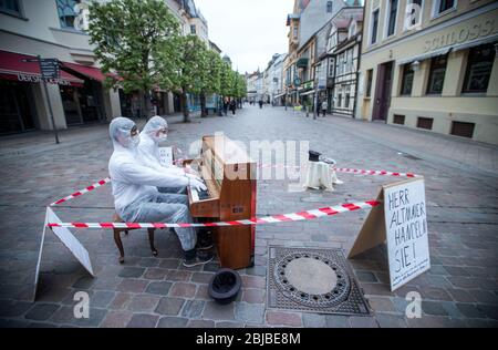 Schwerin, Allemagne. 29 avril 2020. Les musiciens Julian Eilenberger (avant) et. Andreas Güstel joue sur leur piano mobile dans la mecklemburgstraße. Avec leur action, le duo be-Flügelt demande un meilleur soutien et une aide aux artistes indépendants pendant la crise de Corona. Crédit: Jens Büttner/dpa-Zentralbild/dpa/Alay Live News Banque D'Images