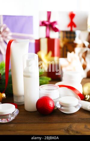 Produits cosmétiques de beauté avec décoration de Noël sur des cadeaux floutés fond Banque D'Images