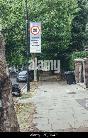 Londres/UK-30/7/18 : panneau sur un pilier montrant un panneau de limite de vitesse de vingt miles par heure et l'inscription « vitesses inférieures, rues plus sûres » sur IT-Board Banque D'Images