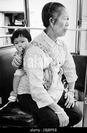 Hong Kong octobre 1986 grand-mère et petit-enfant, Ham Tin, île Lantau. La photo fait partie d'une collection de photographies prises à Hong Kong entre septembre et novembre 1986. Ils représentent un instantané de la vie quotidienne dans la colonie de la Couronne onze ans avant que la souveraineté ne soit transférée en Chine continentale. Photo de Howard Walker / Alay. Banque D'Images