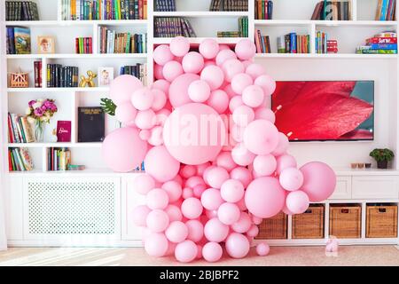 UZHHOROD, UKRAINE - 22 septembre 2019: Deux cent ballons roses inondant la pièce par la porte entre les étagères murales, maison party Banque D'Images