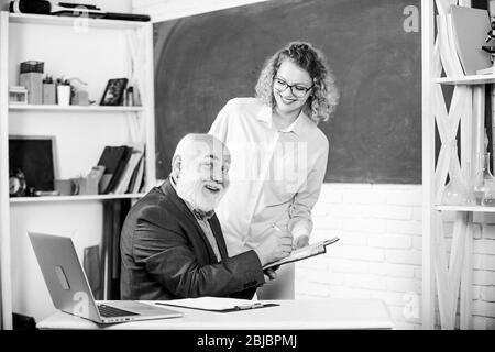 Vérifier les devoirs. Éducateur et étudiant regardant le livre. Expliquer un sujet difficile. L'étudiant est perplexe par quelques informations. Un étudiant demande à l'enseignant la tâche. Résolution des tâches mathématiques. Concept d'éducation scolaire. Banque D'Images