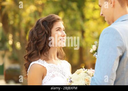 Beau couple de mariage sur fond flou, vue rapprochée Banque D'Images