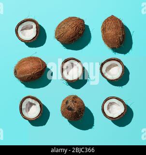 Motif lumineux avec noix de coco. Arrière-plan abstrait tropical. Noix de coco sur fond bleu. Vue de dessus ou plat. Lumière dure Banque D'Images