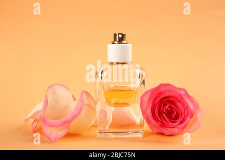 Bouteille de parfum avec fleurs sur fond de pêche Banque D'Images