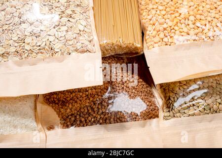 Sacs en papier-cellophane serrés avec des céréales, des légumineuses et des pâtes rapprochés. Sarrasin, pois, lentilles, riz, flocons d'avoine, spaghetti. Zéro déchet alimentaire S Banque D'Images