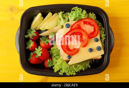 Lunchbox avec dîner sur fond en bois jaune Banque D'Images