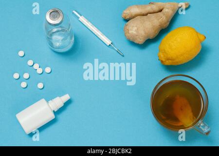 Vaporisateur nasal, pilules, bouteille de verre, thermomètre au mercure, tasse de thé, citron et gingembre. Vue de dessus. Concept de kit de traitement. Les aliments santé pour le col Banque D'Images