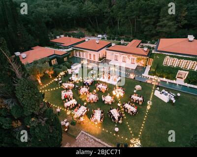 Budva, Monténégro - 10 juin 2019: Banquet de mariage, dîner, au crépuscule sous la lumière des terres de garde. Tables au banquet et une scène avec un groupe musical Banque D'Images