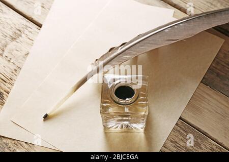 Stylo plume avec inkwell et papiers en blanc sur fond de bois Banque D'Images