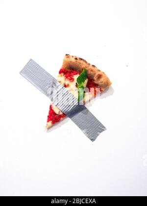 Tranche de SPIzza collée sur le mur avec ruban adhésif rappelant la composition de Maurizio Cattelan Banque D'Images