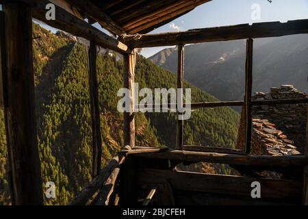 Caucase, Géorgie, région de Tusheti, Kvavlo. Vue sur les montagnes à travers un cadre de fenêtre en bois dans le village abandonné de Kvavlo Banque D'Images