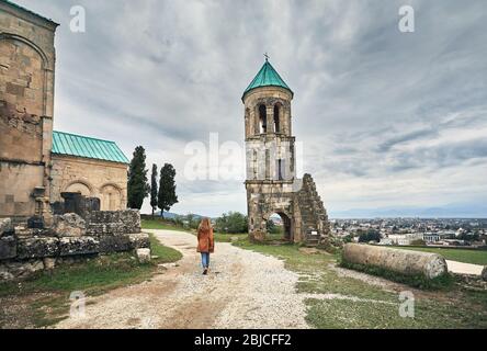 Femme marche à la chapelle de la tour de l'église Bagrati à ciel couvert à Kutaisi, Géorgie Banque D'Images