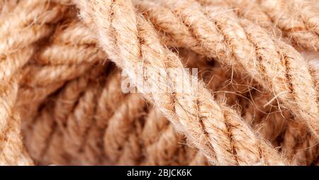 Macro d'antenne de corde, fermeture, texture d'arrière-plan abstraite. Corde solide écologique naturelle marron attaché enchevêtrée structure rugueuse simple vers le haut de près Banque D'Images