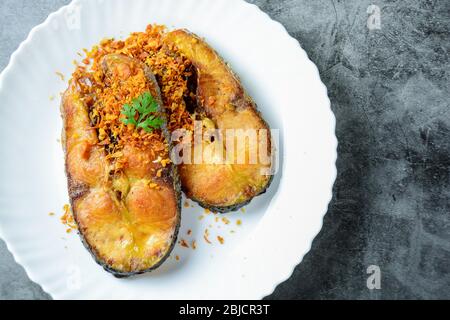 Poisson Pangasius frits avec ail et source de poisson au poivre noir, plat rapide et facile. Banque D'Images