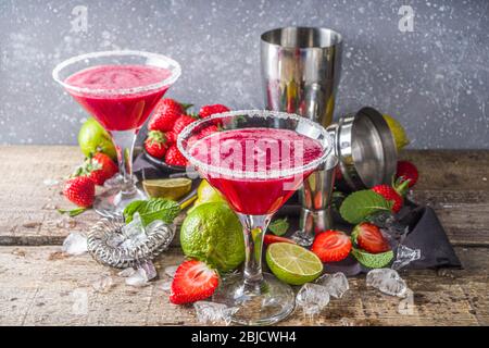 Boisson alcoolisée froide d'été. Cocktail de marguerite de fraise, avec citron vert, menthe et fraise fraîche sur fond rustique en bois Banque D'Images