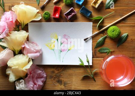 Peinture aux aquarelles avec fleurs sur table en bois Banque D'Images