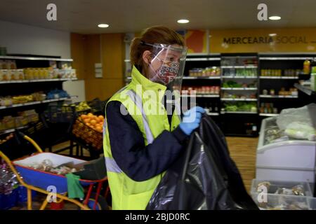 Un volontaire portant un masque de protection et des gants emballe de la nourriture et d'autres fournitures à distribuer aux résidents du district.le Conseil communal de Penha de França a réalisé un projet appelé 'magasin d'alimentation sociale', lorsqu'une structure est utilisée pour stocker des produits alimentaires et d'hygiène personnelle donnés par les supermarchés et les écoles. Ces derniers sont emballés et ensuite distribués par des travailleurs bénévoles à des personnes, en particulier les personnes âgées et les malades, qui sont sans abri ou physiquement incapables, et qui sont dans une situation vulnérable en raison de la séquestration obligatoire en raison de la pandémie de COVID-19. Banque D'Images