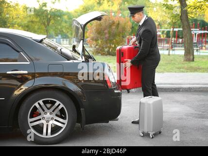 Valise de transport avec chauffeur dans le coffre de la voiture Banque D'Images