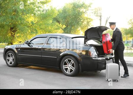 Valise de transport avec chauffeur dans le coffre de la voiture Banque D'Images