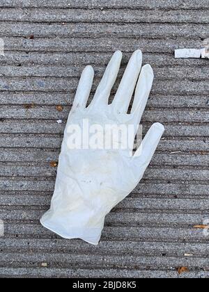 Les gants en caoutchouc jetés sont maintenant régulièrement vus des ordures sur les trottoirs et les rues depuis l'éclosion du coronavirus dans toute la ville de New York. Banque D'Images