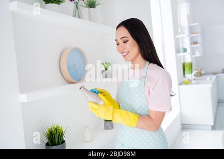 Gros plan portrait de sa belle belle gaie gaie gaie gentille brune fille rondelle portant des gants jaunes essuyant des trucs poussière dans blanc moderne Banque D'Images