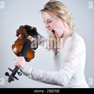 violoniste féminin criant sur son instrument Banque D'Images