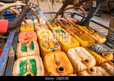 MALI, Kayes, Sadiola, station de stockage et de remplissage d'eau, l'eau est stockée dans de grands sacs de film plastique à vendre à de petites entreprises de goldmineurs, transport en chinois à trois roues / Wassertankstelle, Wasserspeicher à grossen Säcken, Verkauf an Goldwäscher Banque D'Images