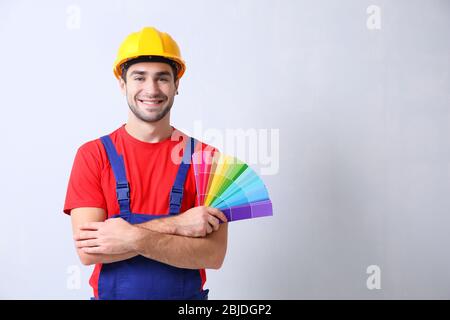 Le travailleur tient des échantillons pour choisir la couleur du mur Banque D'Images