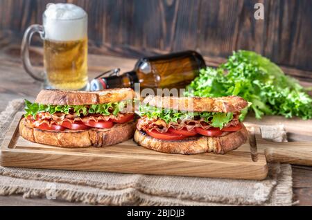 Sandwichs BLT au bacon, à la laitue et aux tomates sur le panneau de bois Banque D'Images