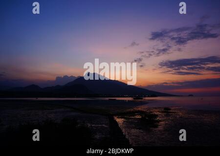 Coucher de soleil ou lever de soleil derrière la montagne, côte nord de l'île de Java, Indonésie Banque D'Images