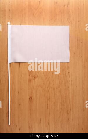 Drapeau blanc pour la marque sur table en bois Banque D'Images