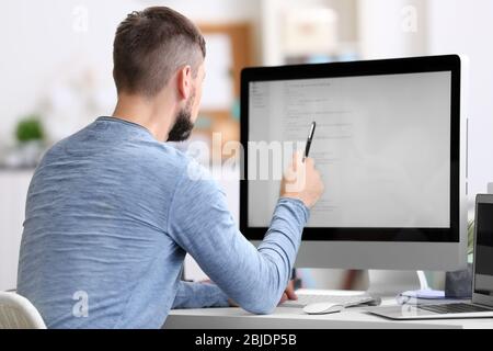 Beau jeune programmeur travaillant au bureau Banque D'Images