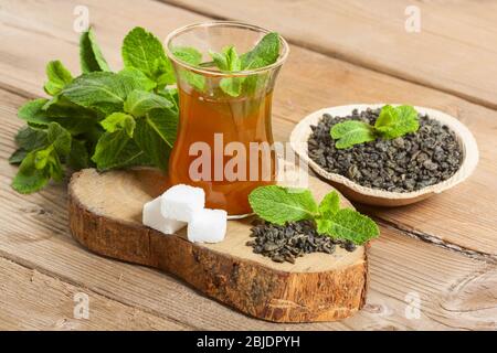 Thé marocain à la menthe et au sucre dans des verres sur fond en bois. Banque D'Images