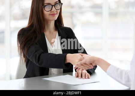 Concept d'entretien de poste. Responsable des ressources humaines secouant la main de la femme, à proximité Banque D'Images