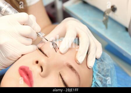 Cosmetologist appliquant le maquillage permanent sur les sourcils Banque D'Images