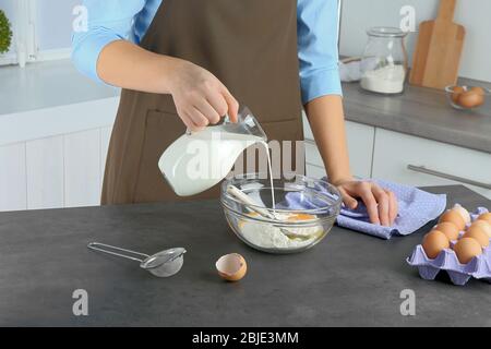 Mains féminines préparant la pâte sur la table de cuisine Banque D'Images