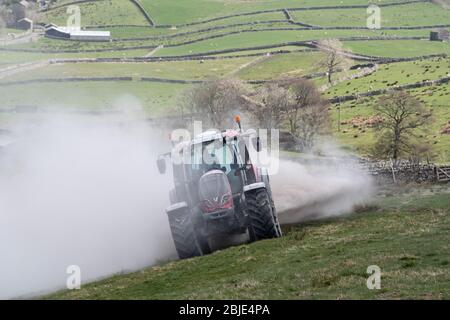 Limespreading sur les pâturages de montagne pour améliorer sa productivité et sa qualité. Hawes, Yorkshire du Nord, Royaume-Uni. Banque D'Images