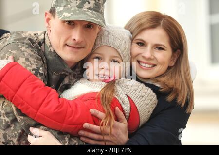 Soldat en camouflage rencontre sa famille à l'extérieur Banque D'Images