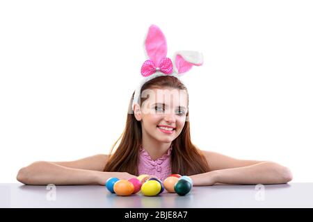 Belle fille avec des oreilles de lapin et des œufs de Pâques sur fond blanc Banque D'Images