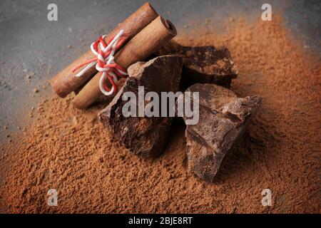 Morceaux de chocolat avec bâtonnets de cannelle et poudre de cacao, clôture Banque D'Images
