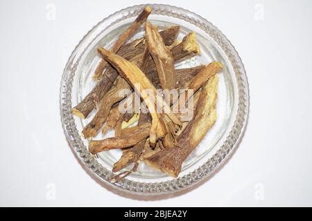 Fond blanc Licorice ou réglisse ou Mulethi est la racine de glycyrrhiza glabra d'un flatour doux peut être extrait. Utilisé dans le thé aux herbes en Asie Midd Banque D'Images