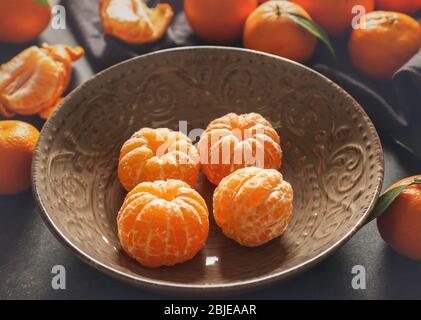 Mandarine pelée en plaque sur la table grise Banque D'Images