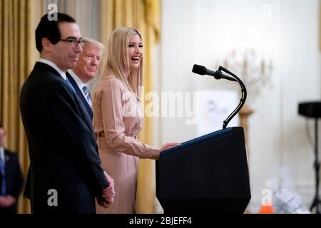 Washington, États-Unis d'Amérique. 28 avril 2020. Washington, États-Unis d'Amérique. 28 avril 2020. La première fille des États-Unis, Ivanka Trump, s'adresse à des remarques lors d'un événement de petite entreprise sur le programme de protection des chèques de paye adopté par le Congrès dans la salle est de la Maison Blanche le 28 avril 2020 à Washington, DC. Sur scène de gauche à droite, se trouvent le secrétaire au Trésor Steve Mnuchin, le président Donald Trump et Ivanka Trump. Crédit : TIA Dufour/White House photo/Alay Live News Banque D'Images