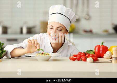 Chef femelle préparant dans la cuisine Banque D'Images