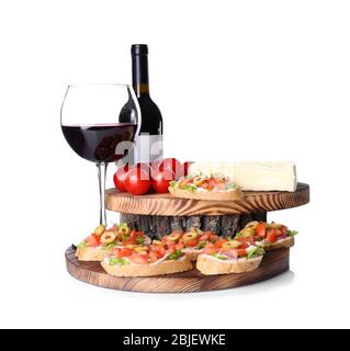 Savoureuse bruschetta servie avec du vin sur fond blanc Banque D'Images