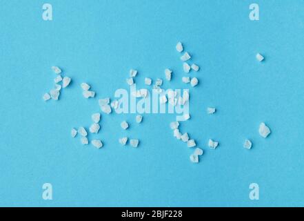 Granules de sel de mer isolés sur fond bleu. Banque D'Images